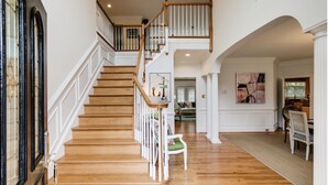 A grand staircase with wooden steps and white railings, leading to an upper floor. - Great Get Away Home  (Henrico)