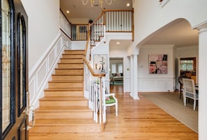 Un magnifique escalier en bois, avec des marches en bois et des rampes blanches, menant à l’étage supérieur.