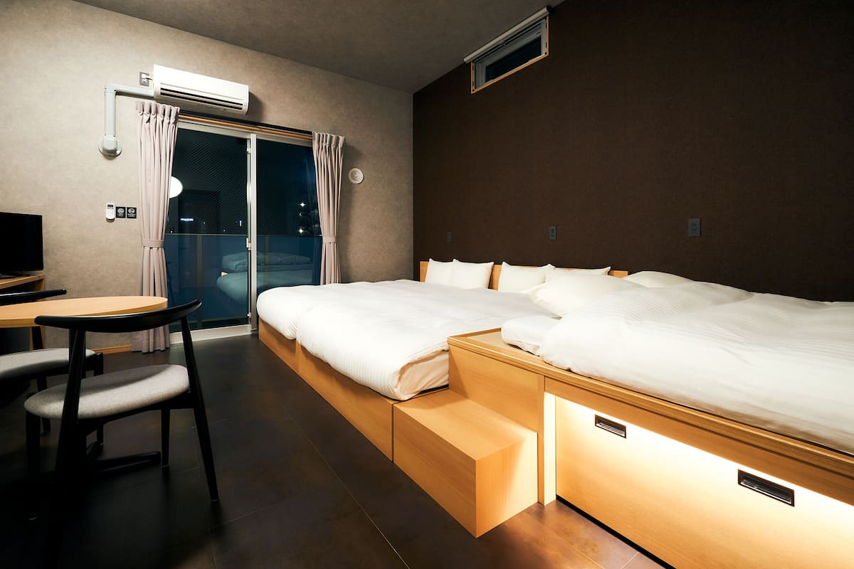 A hotel room with a bed, a desk, and a chair.
