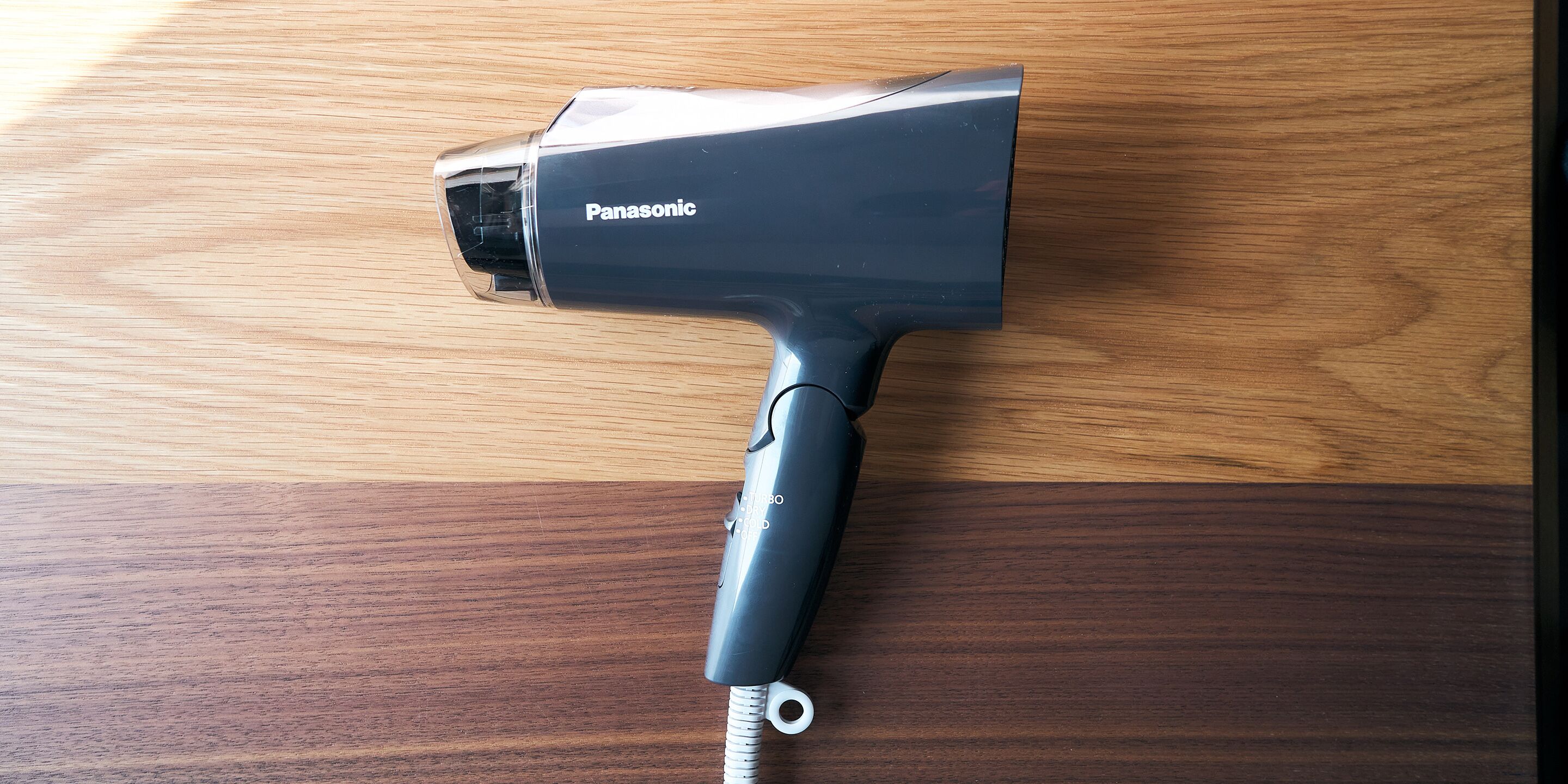 Un secador de pelo Panasonic sobre una superficie de madera.