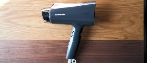 Un secador de pelo Panasonic sobre una superficie de madera.