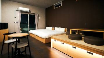 Une chambre d’hôtel moderne équipée d’un lit, d’un bureau, d’une chaise, d’une petite table et d’un canapé.