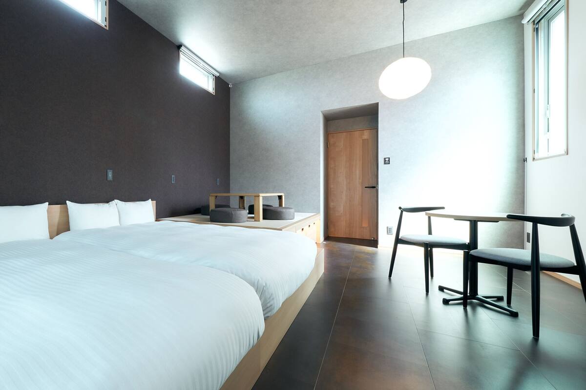A modern hotel room with a large bed, a desk, and a chair.