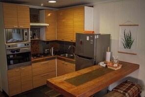 Kitchen features an oven, microwave, and refrigerator, along with a sink and kettle.