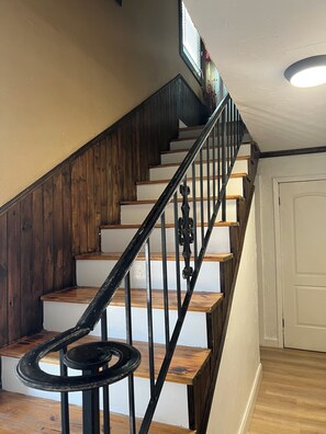 A staircase with wooden steps and black metal railings.