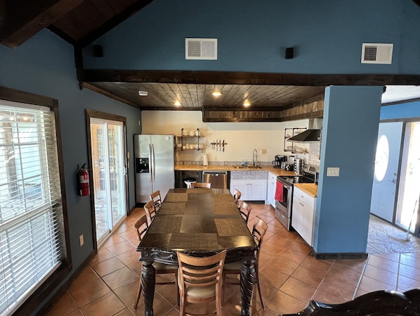 A spacious kitchen with a long dining table, a refrigerator, and a sink. - Spacious  4 bedroom home /sleeps 10 /just minutes from State and National Park.  (Terlingua)