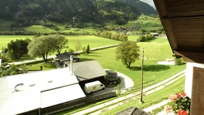 Une vue d’un paysage rural avec un bâtiment doté d’un espace de stationnement couvert et d’un fourgon blanc garé à l’intérieur.