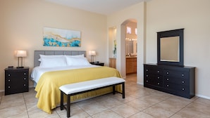 A bedroom with a bed, bedside tables, a bench, a dresser, a mirror, and a painting on the wall. - Private home,2 King Beds, near Empire Polo, Tennis, Pools, Coachella, Horse Pk, (Indio)