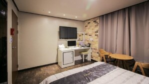 A hotel room with a bed, desk, chair, television, and a small table. - Hotel The May (Busan)