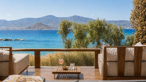 A wooden deck with a hot tub, lounge chairs, and a table with a drink and snacks. - Avgoustos Suites - Adults only (Naxos)