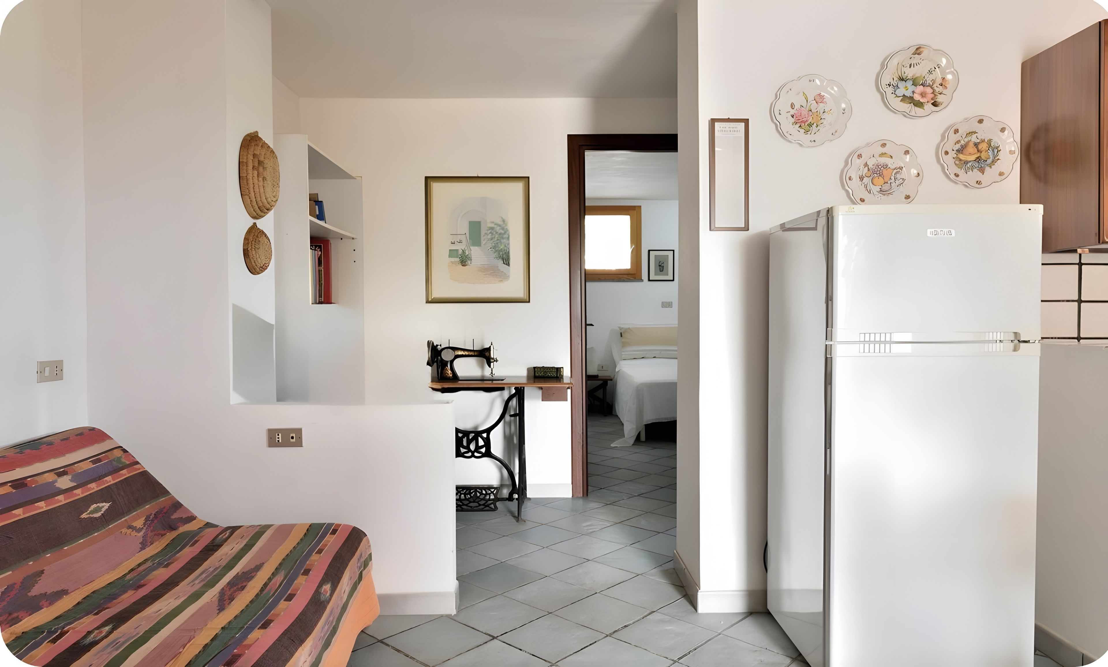 Een knus woongedeelte met een kitchenette, een bed en een eethoek.