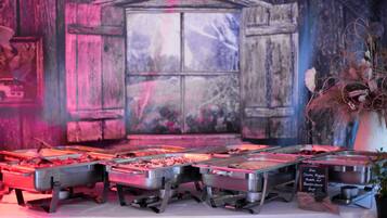 A buffet setup with various food options, a chalkboard menu, and a rustic backdrop.