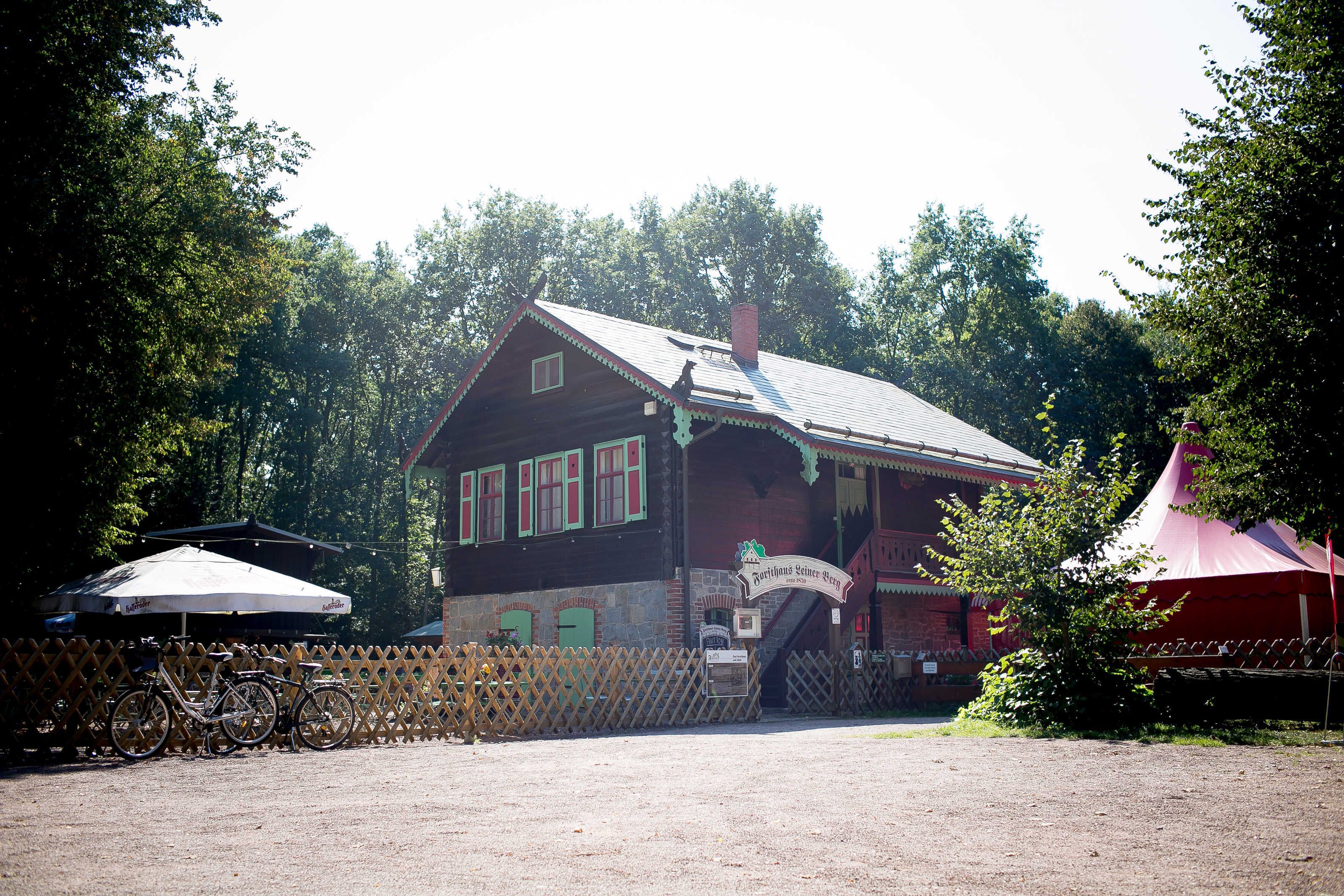 A wooden building with a porch, a bicycle, and a sign.