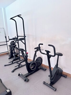 A gym with stationary bikes, a treadmill, and a rack of dumbbells. - Rose Garden Private Apartment By LINK (Kigali)