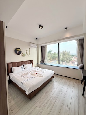 A hotel room with a large bed, a window seat, and a view of the outside. - Rose Garden Private Apartment By LINK (Kigali)