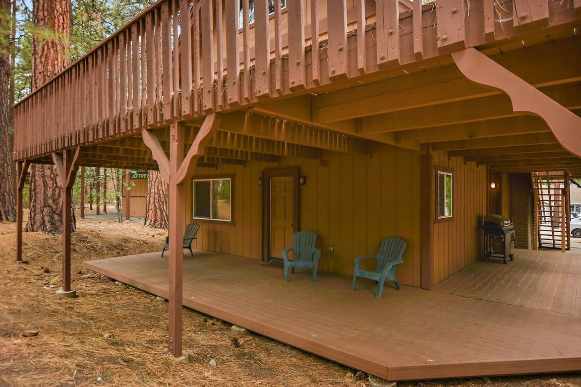 Eine Holzhütte mit Veranda, zwei Stühlen und einer Tür.