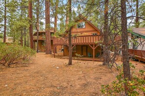 A cabin with a wooden deck and multiple windows, surrounded by tall pine trees. - Redwood Lodge by Destination Big Bear : Close to Snow Summit and Short Drive to Lake & Village! Air Hockey! (Big Bear Lake)