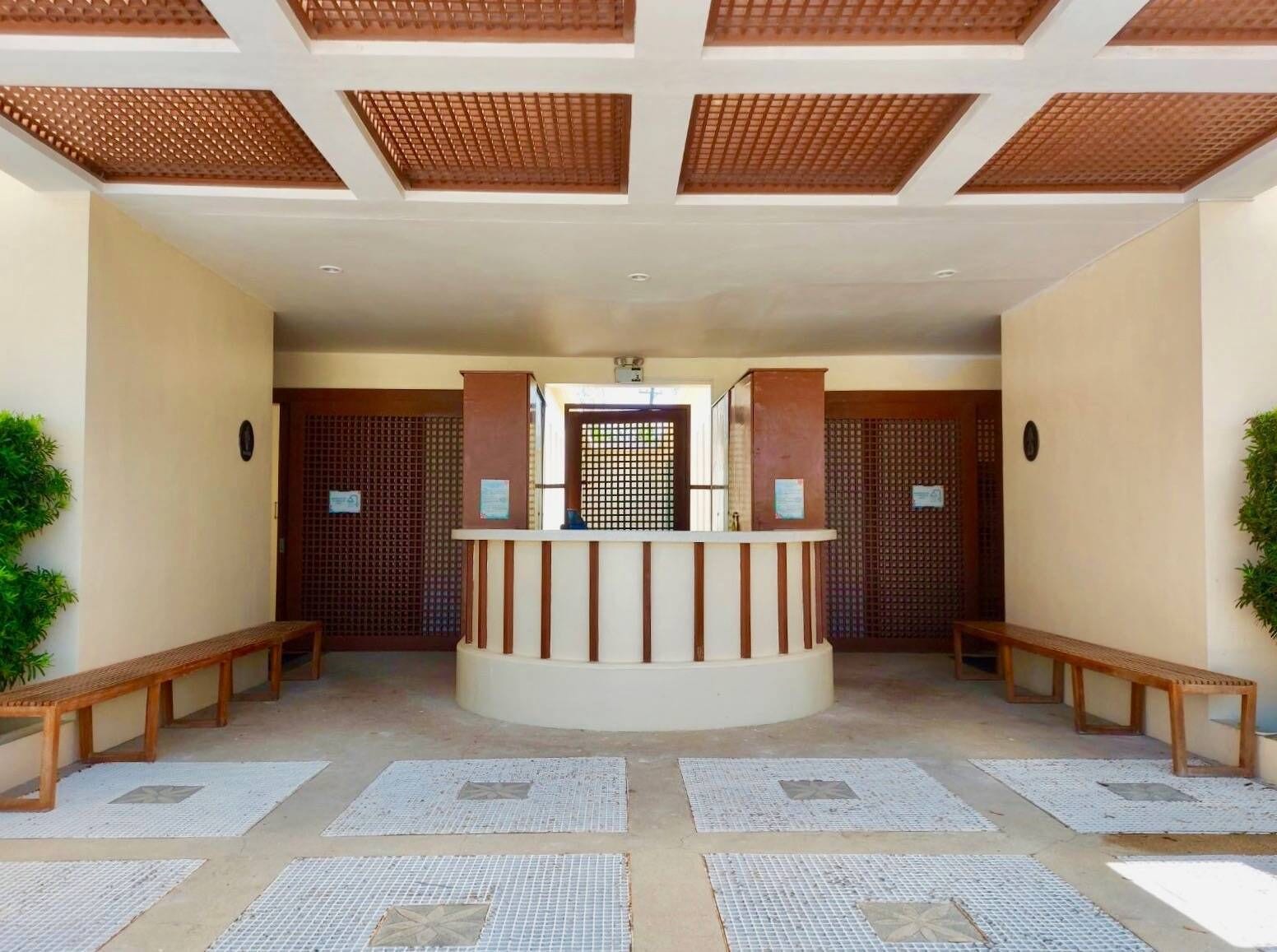 A reception area with a central desk, benches, and a patterned floor.