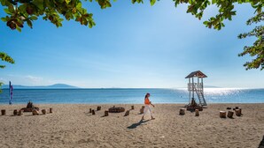 A beach with a wooden structure, a person, and a clear sky. - Cocoons Casobe (Calatagan)
