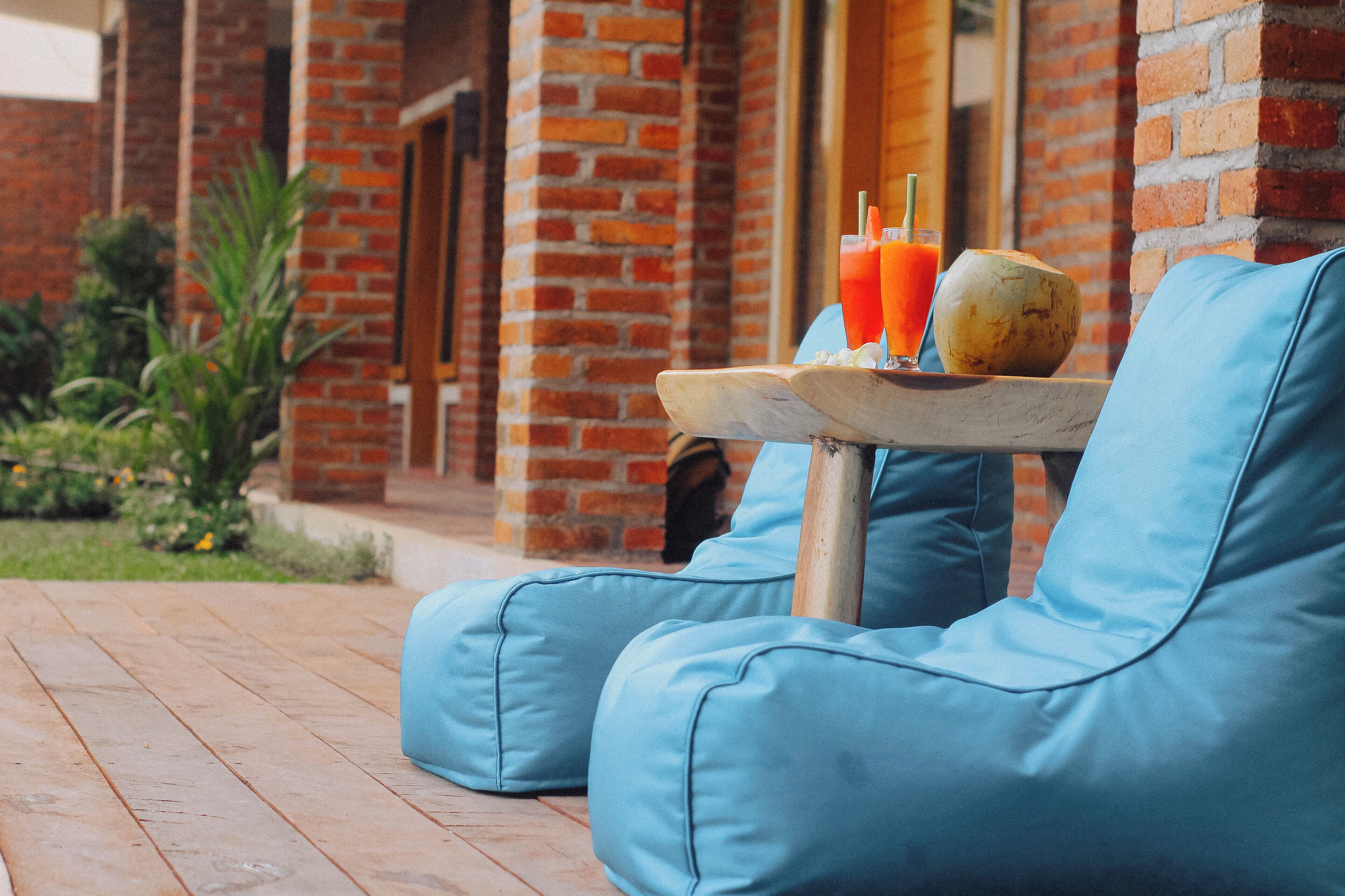 A brick building with a wooden deck and blue cushioned seating.