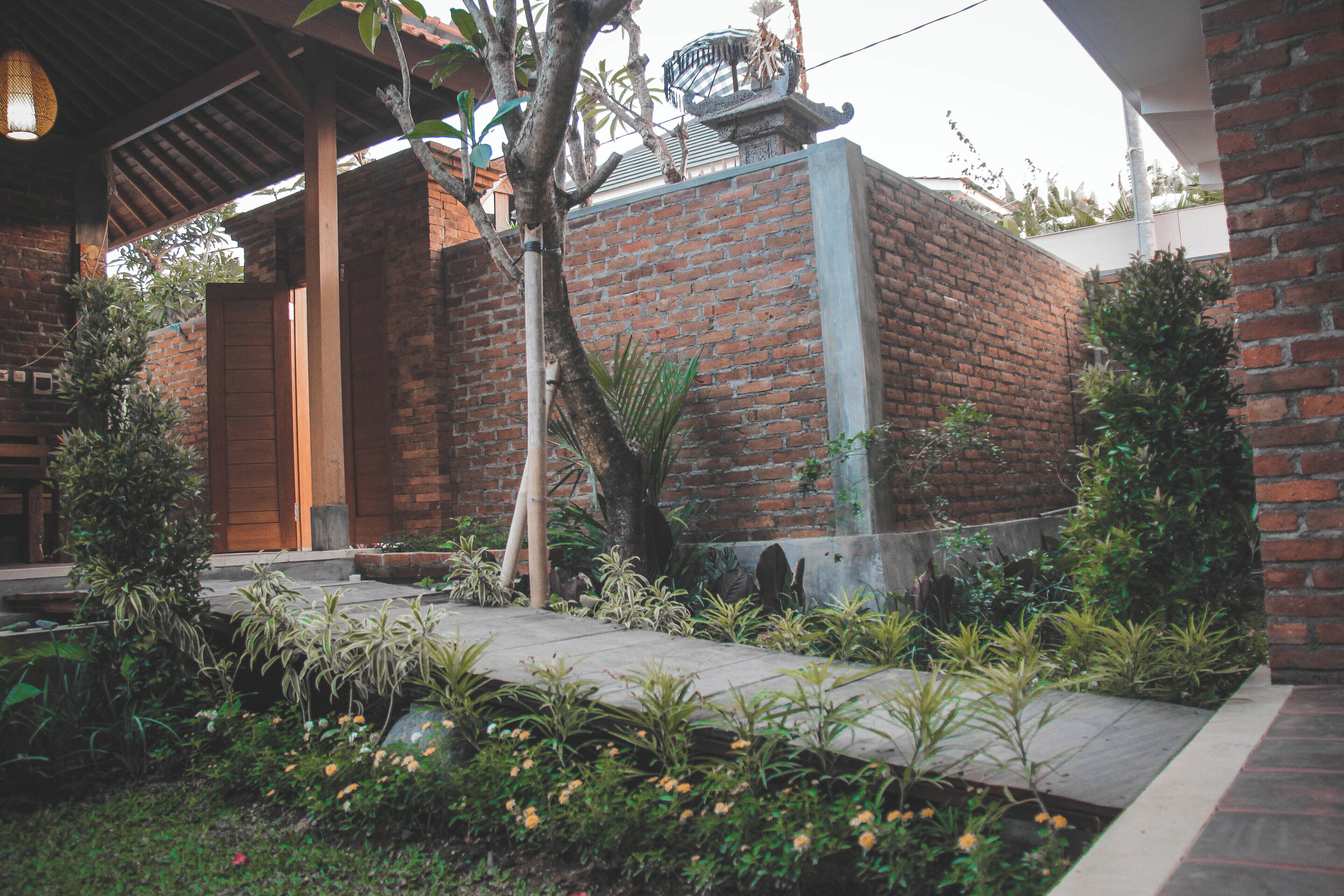 Un edificio de ladrillo con puerta de madera y un corredor cubierto.
