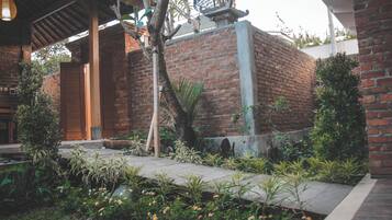 Un edificio de ladrillo con puerta de madera y un corredor cubierto.