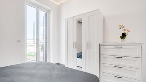Una camera da letto con un letto, un'armadio bianco e una finestra vista.