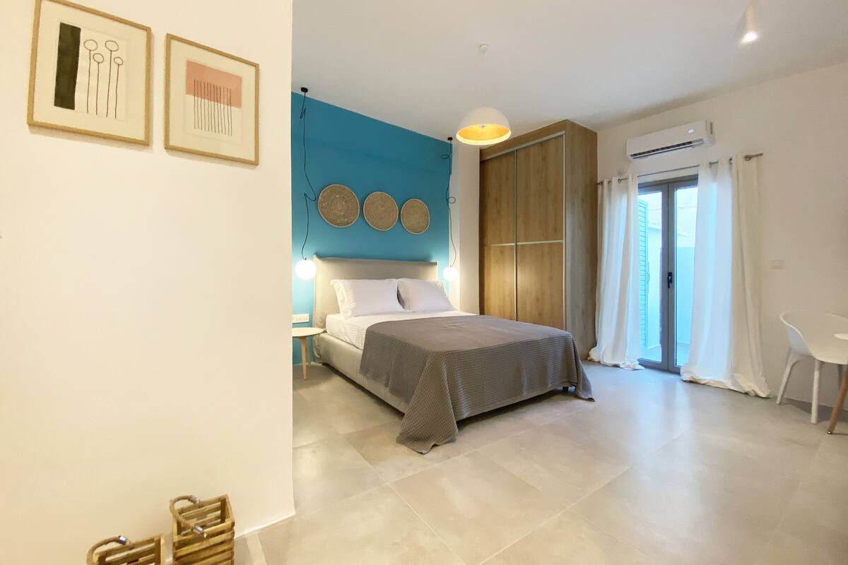 A modern bedroom with a bed, bedside tables, a wardrobe, and a window with curtains.