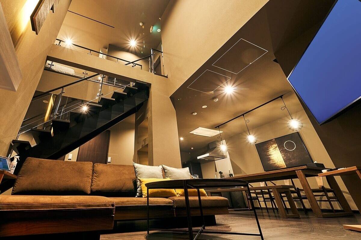 Un interior moderno con un sofá, una mesa de comedor y una escalera.