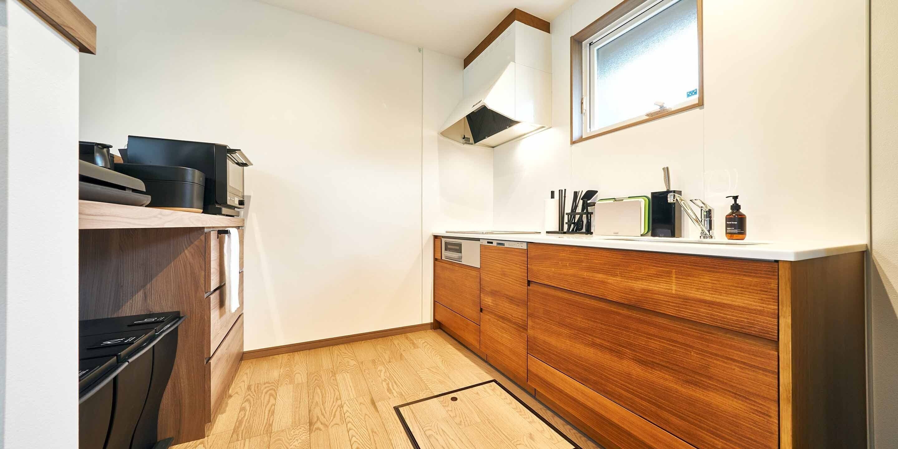 Una cocina moderna con armarios de madera, lavavajillas integrado y una ventana sobre el fregadero.