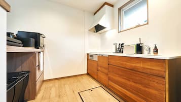 Una cocina moderna con armarios de madera, lavavajillas integrado y una ventana sobre el fregadero.