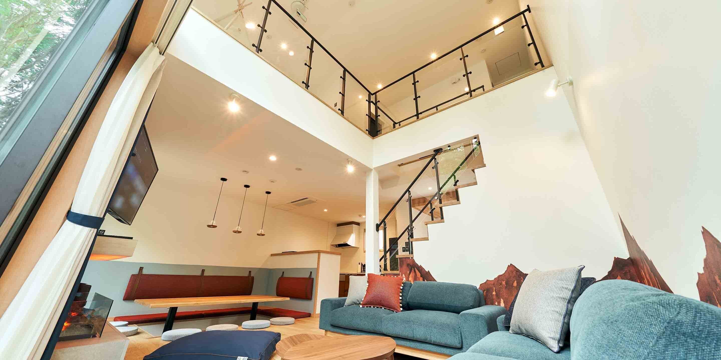 Un interior moderno con una escalera, una zona de estar y un sofá.