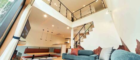 Un interior moderno con una escalera, una zona de estar y un sofá.