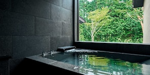 A modern bathroom with a large window, a built-in bathtub, and a view of a lush green garden. - Rakuten STAY VILLA Hakone Sengokuhara (Hakone)