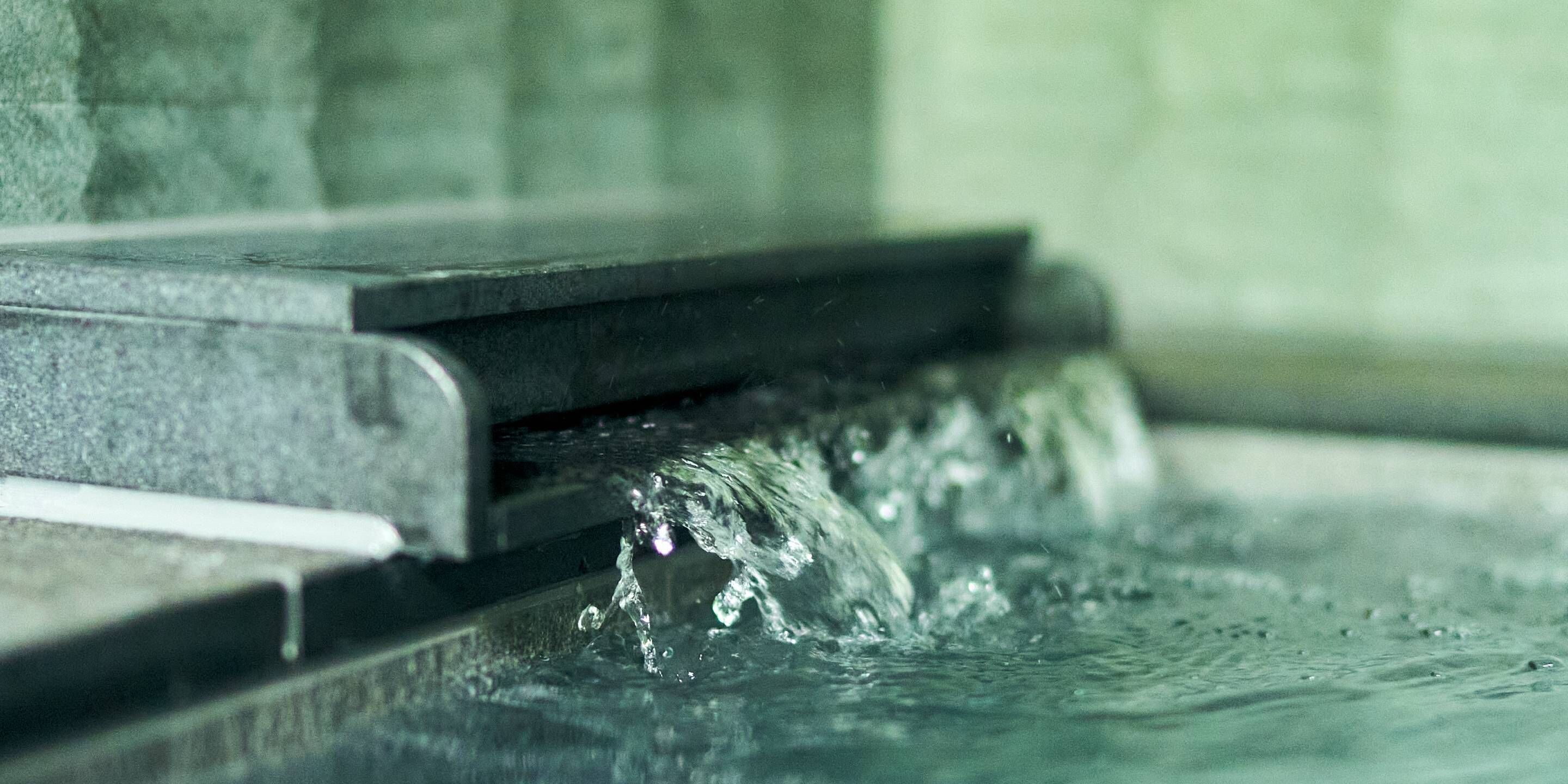 A close-up of water flowing over a stone ledge.