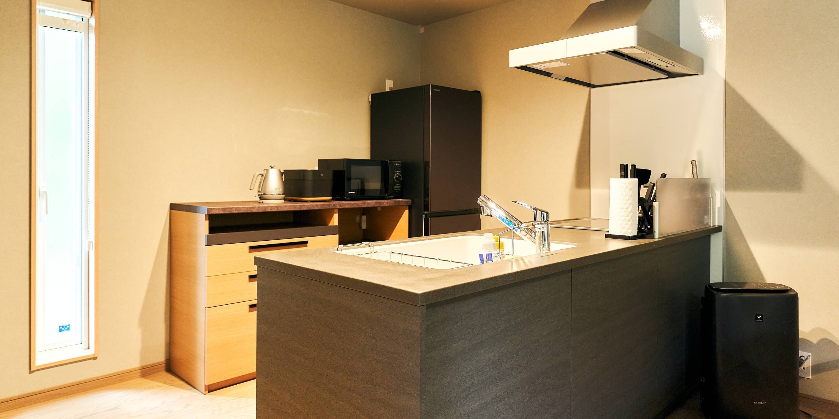 A modern kitchen with a central island, built-in appliances, and a window for natural light.
