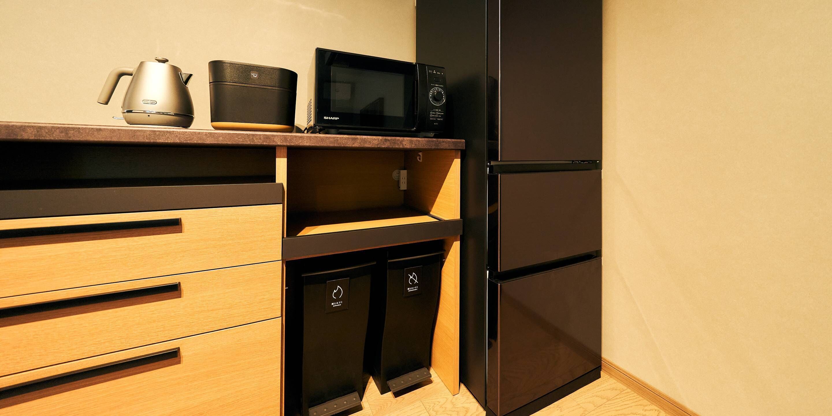 A compact kitchen with a microwave, a coffee maker, and a refrigerator.