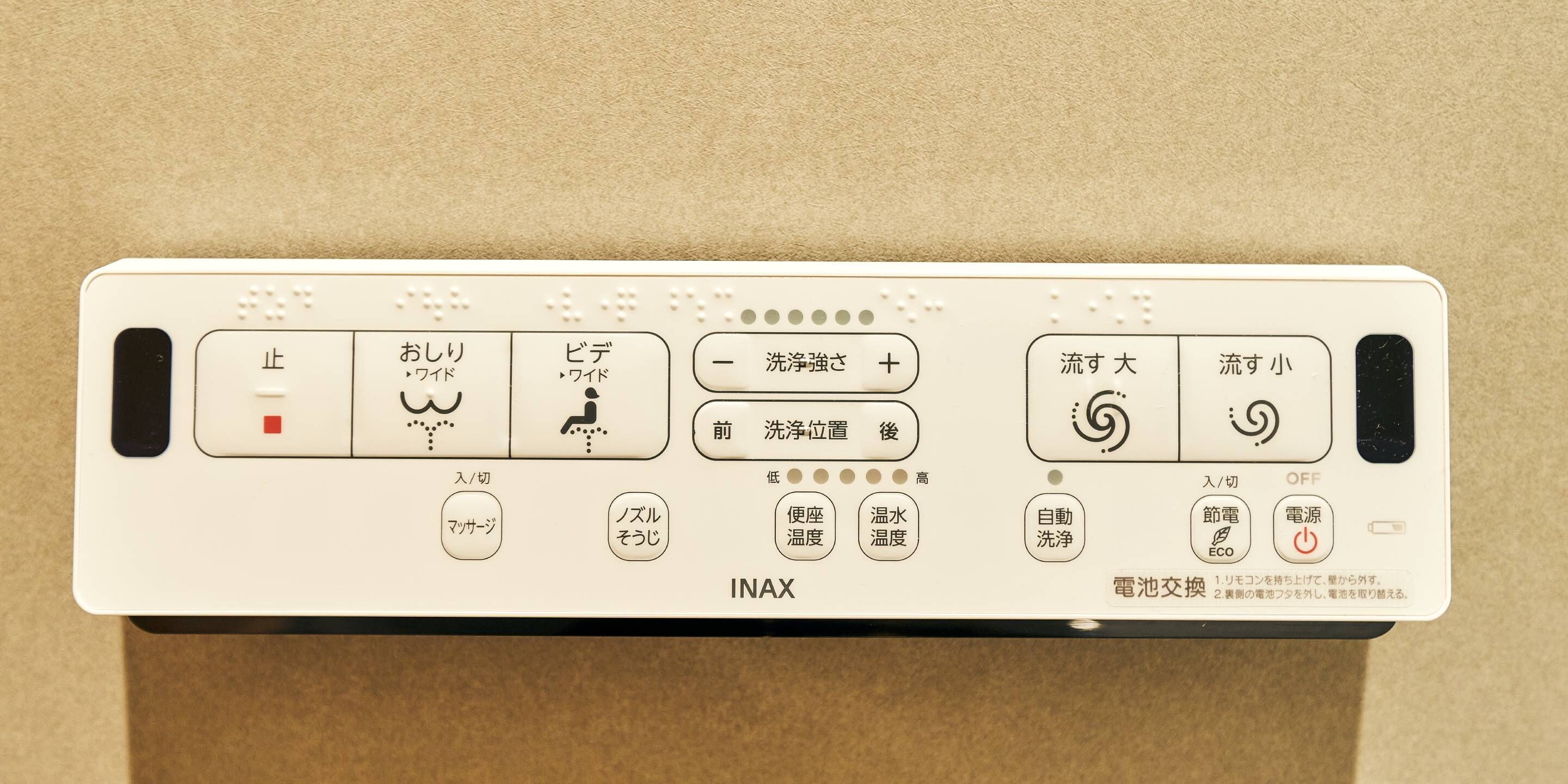 Un panneau de commande avec des instructions en japonais pour un appareil, comprenant des boutons pour l’alimentation, les réglages et les fonctions.