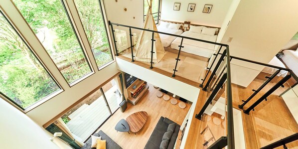 A modern loft-style room with large windows, a loft bed, a sofa, and a dining area. - Rakuten STAY VILLA Hakone Sengokuhara (Hakone)