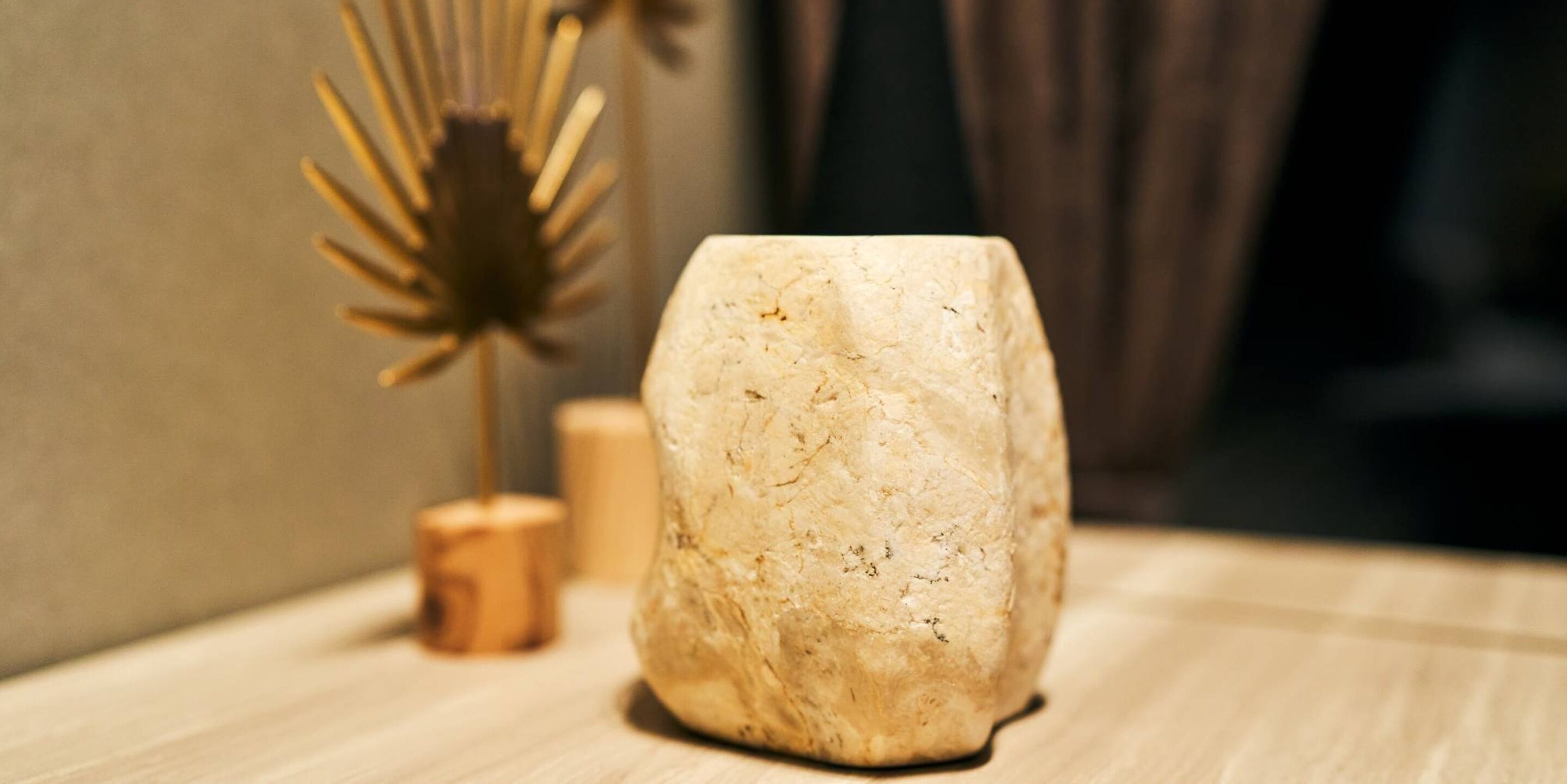 A stone sculpture on a wooden surface with a blurred background.