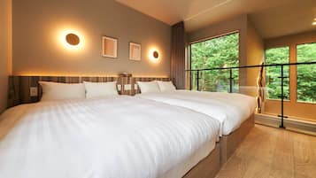 Ein modernes Hotelzimmer mit einem großen Bett, Blick auf Bäume vom Balkon aus und Wandleuchten.