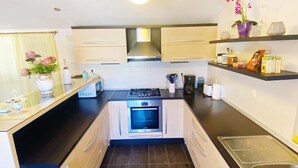 A compact kitchen with a gas stove, oven, and modern cabinetry.