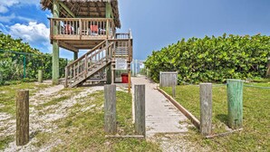 A wooden observation tower with a thatched roof, a staircase, and a pathway leading to it. - Jensen Beach Home: Walk to Beach Access! (Jensen Beach)