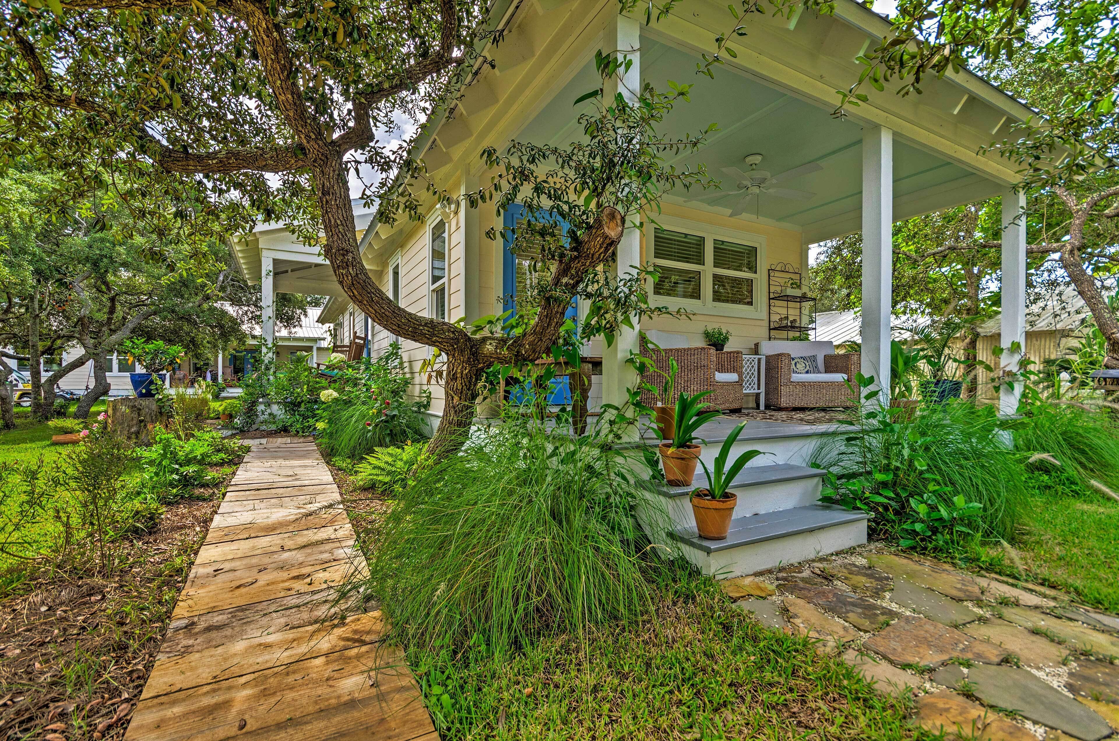 A covered porch with a wooden walkway leading to a house.