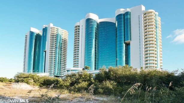 Un hotel moderno a più piani, con una facciata in vetro ben evidente e numerosi balconi.