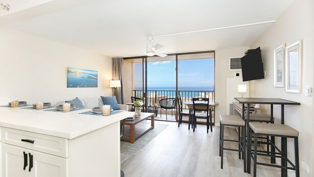 Ein modernes Hotelzimmer mit Balkon, Essbereich und Küche.
