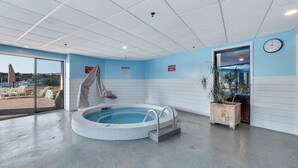 Un espace piscine doté d’une porte vitrée donnant sur l’extérieur, d’une horloge murale et d’un panneau indiquant les règles à respecter dans la piscine.