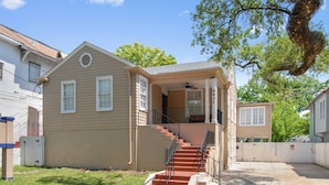 A two-story house with a front porch, a staircase, and a fenced yard. - Canal DOWN |Streetcar Line MidCity| Add More Space (New Orleans)