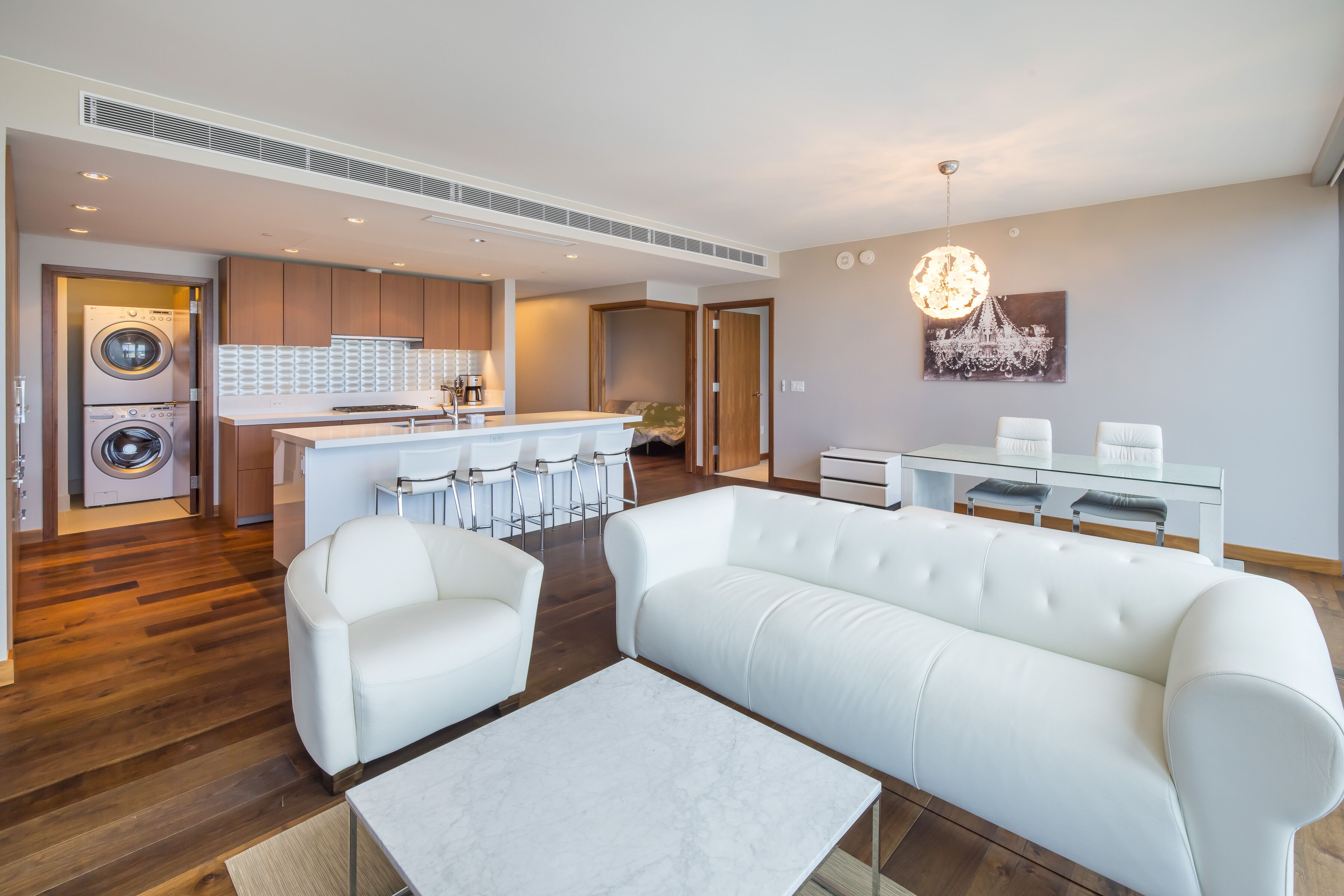 Um apartamento moderno com sala de estar, cozinha e lavanderia.