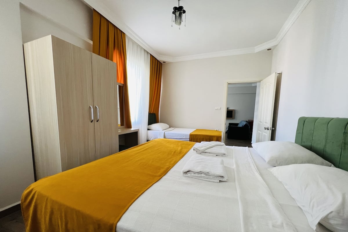 A hotel room with two beds, a wardrobe, and a television.